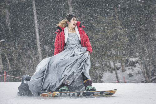 カラードレスでスノーボードをする新婦