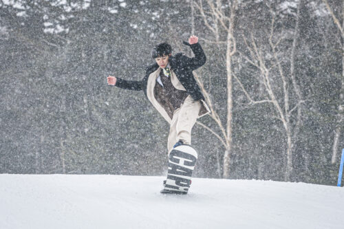 タキシードでスノーボードをする新郎