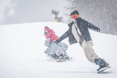 ウェディングドレスとタキシードでスノーボードを滑る新郎新婦2