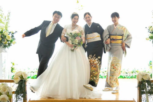KKRポートヒル横浜のチャペルで足を上げてポーズをとる新郎新婦とご家族