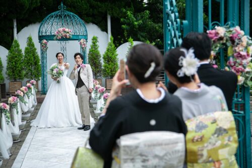 KKRポートヒル横浜のガーデンチャペルのガゼボと白のバージンロードで撮影する新郎新婦とご家族