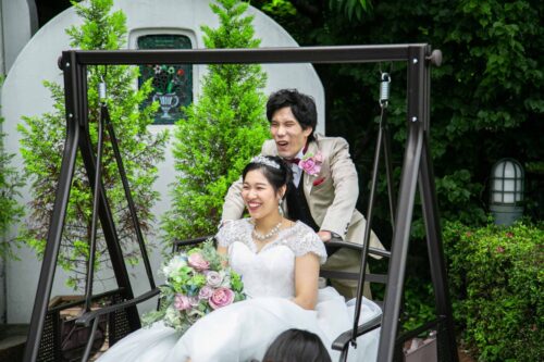 KKRポートヒル横浜のガーデンチャペルのブランコで撮影する新郎新婦