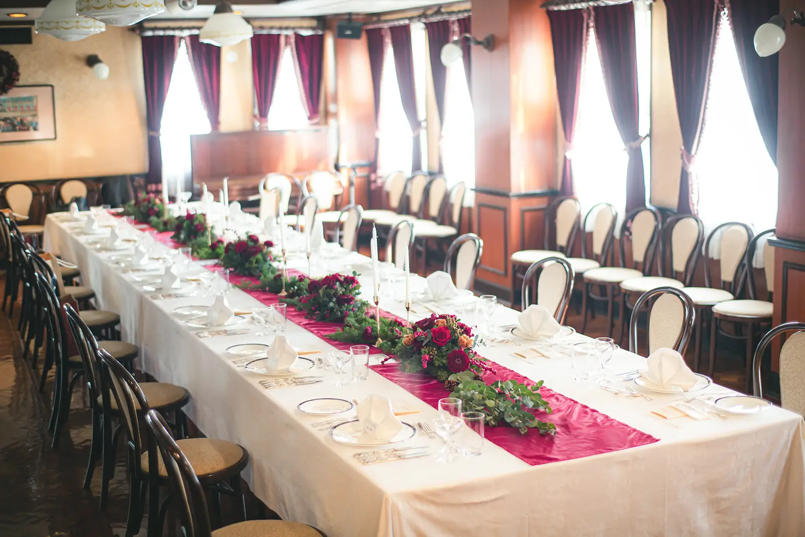 横浜・馬車道十番館のクラシカルな会食会場。華やかなテーブル装花が飾られた長テーブルが並び、落ち着いたレトロな雰囲気が広がるレストランウェディングの様子。