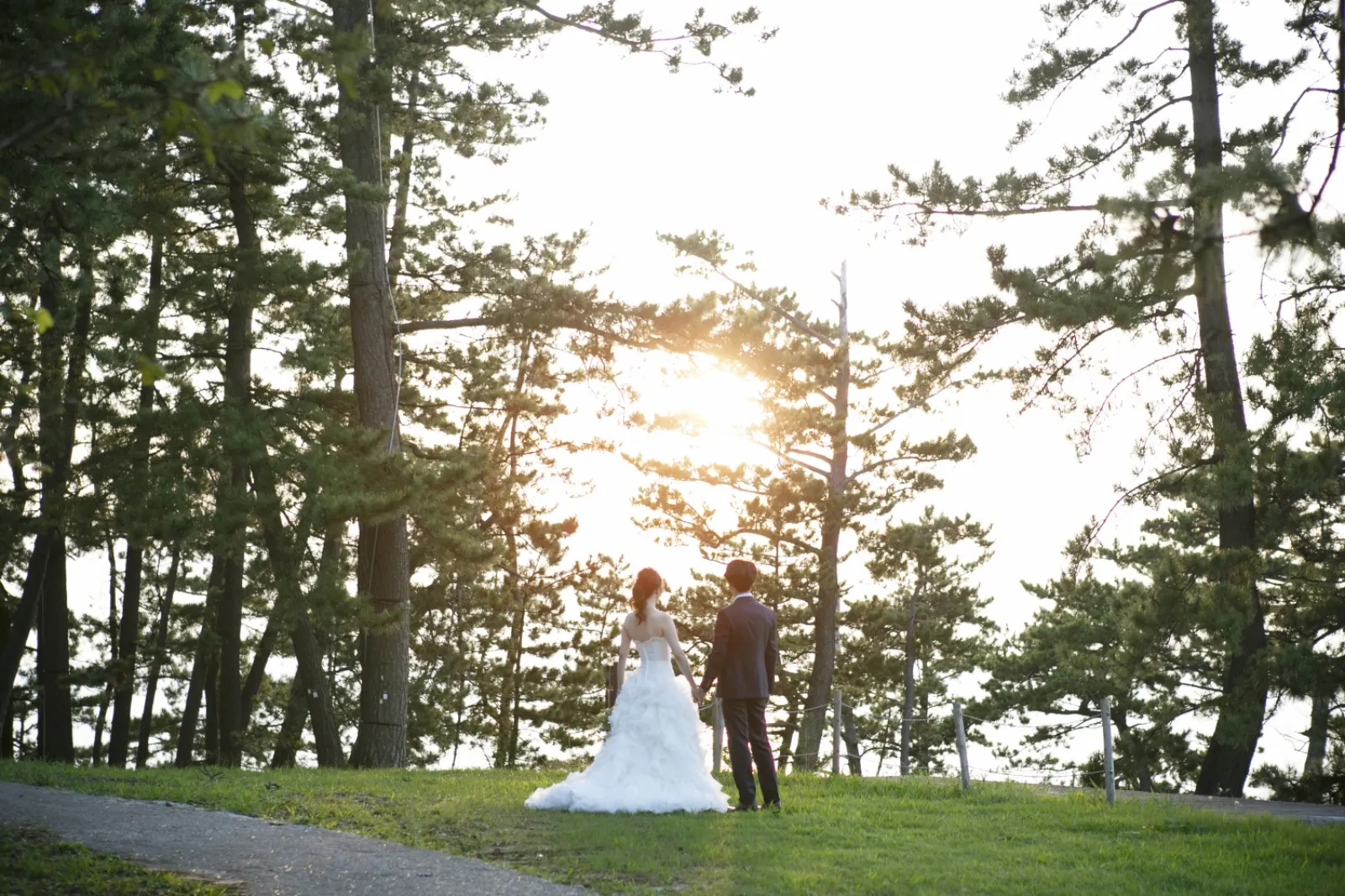 巌門の夕景のなかで指輪を交換する新郎新婦