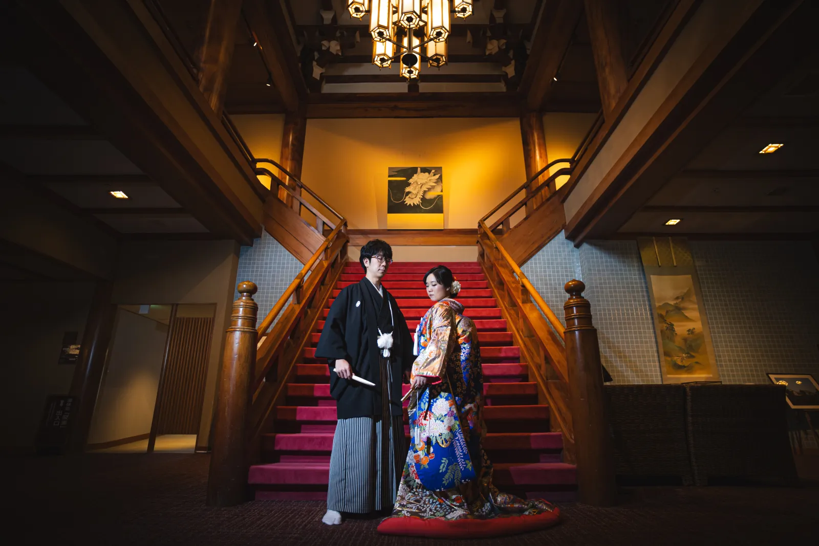 90年の歴史ある龍宮殿の豪華なロビーで和装撮影をする新郎新婦