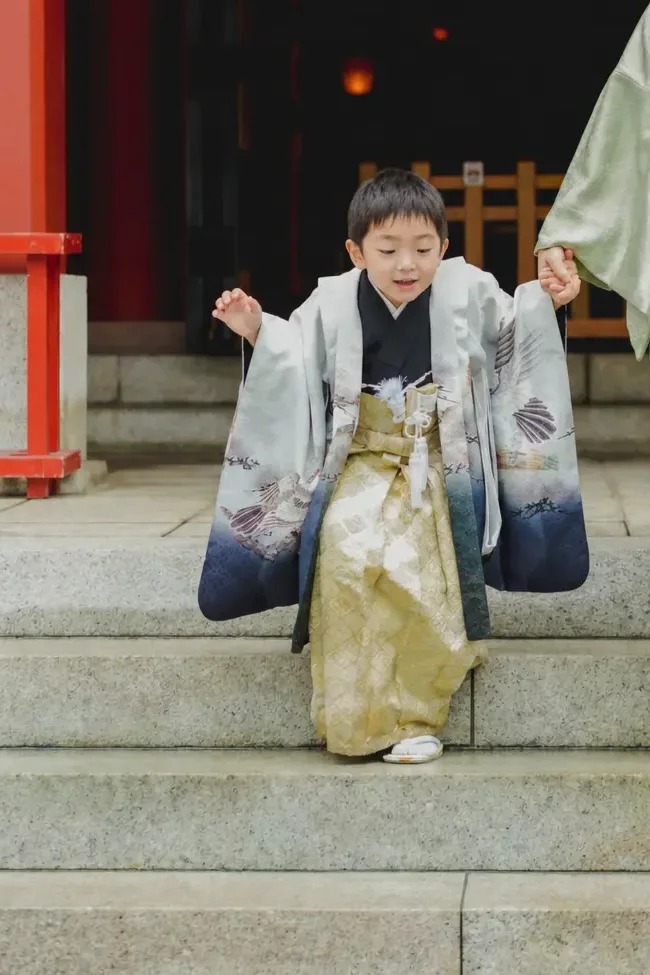 日枝神社の石段を母と手をつないで一段ずつ降りてくる羽織袴姿の5歳の男の子、七五三出張撮影（東京）