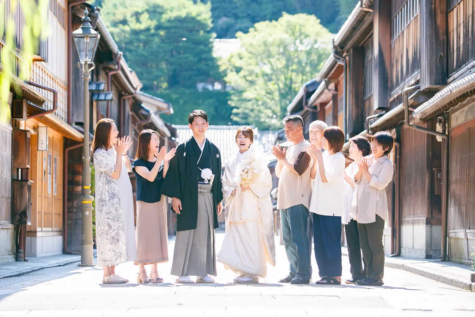 金沢のひがし茶屋街で家族に囲まれながら和装姿で立つ新郎新婦