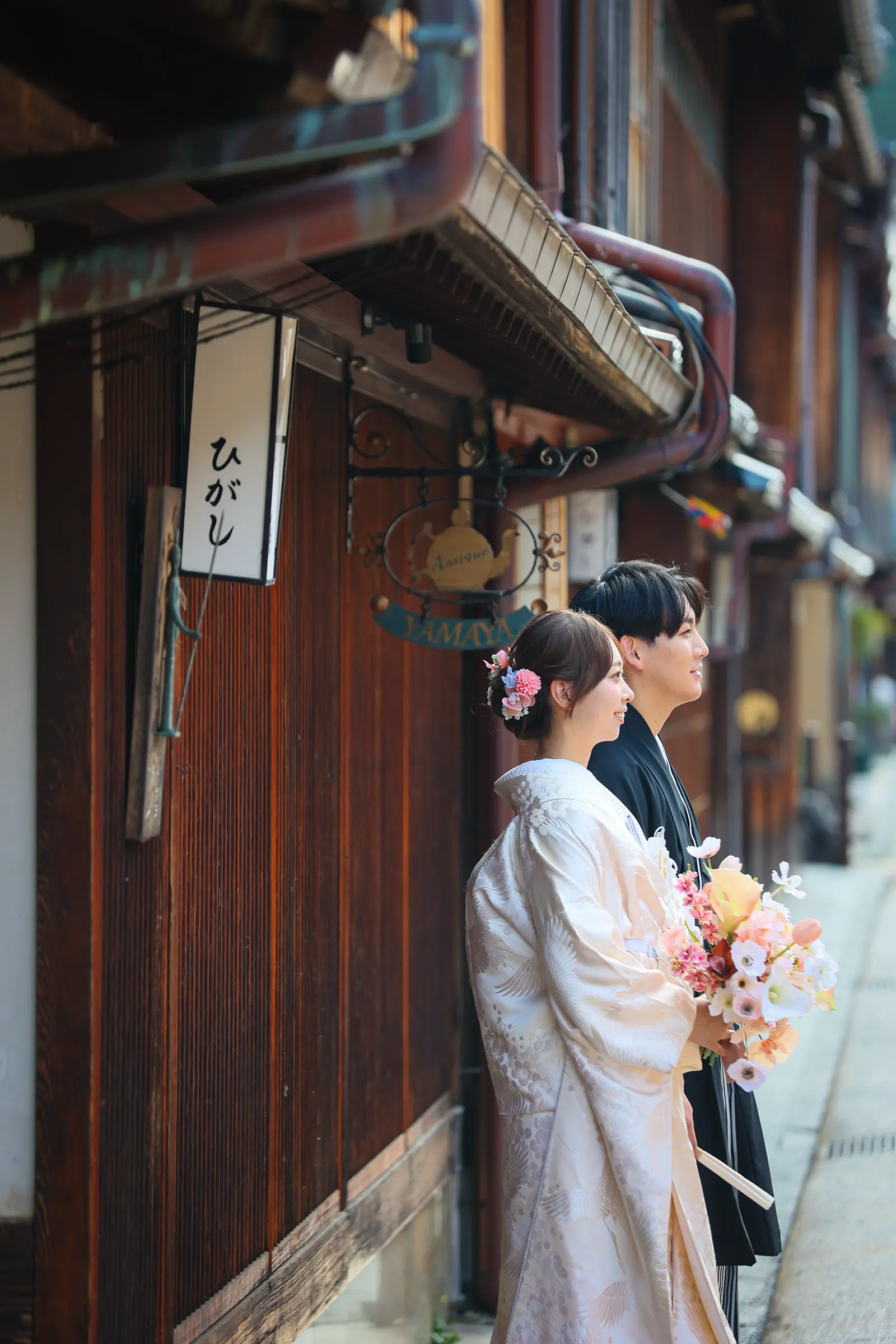 金沢のひがし茶屋街の町家沿いに立つ和装姿の新郎新婦の横顔