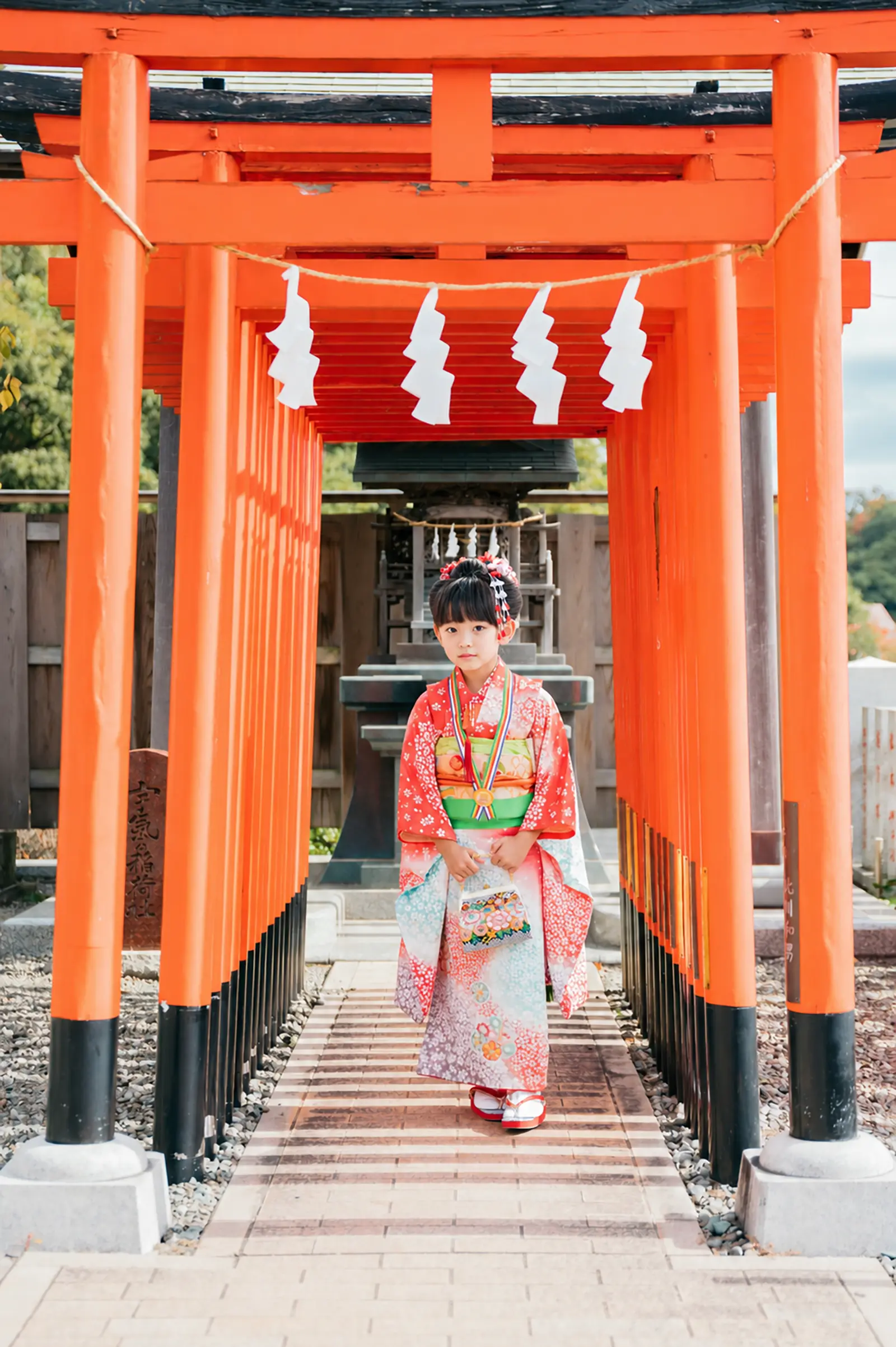 本牧神社の稲荷社に続く朱の鳥居のなかに立つ7歳の女の子、四つ身の七五三出張撮影（横浜市中区）