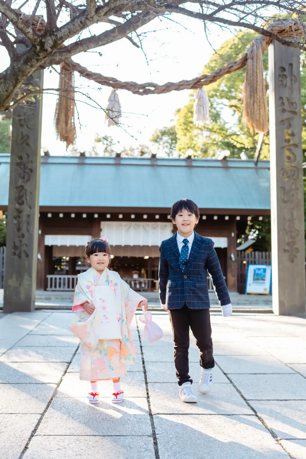 注連縄の下を並んで歩いてくる兄妹、七五三の被布姿の3歳の女の子（伊勢山皇大神宮・横浜）