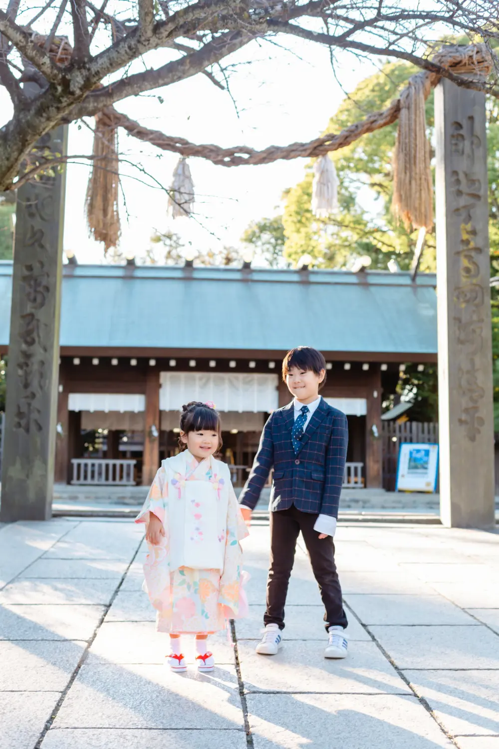 注連縄の下に並ぶ兄妹の引きの一枚、七五三の被布姿の3歳の女の子（伊勢山皇大神宮・横浜）