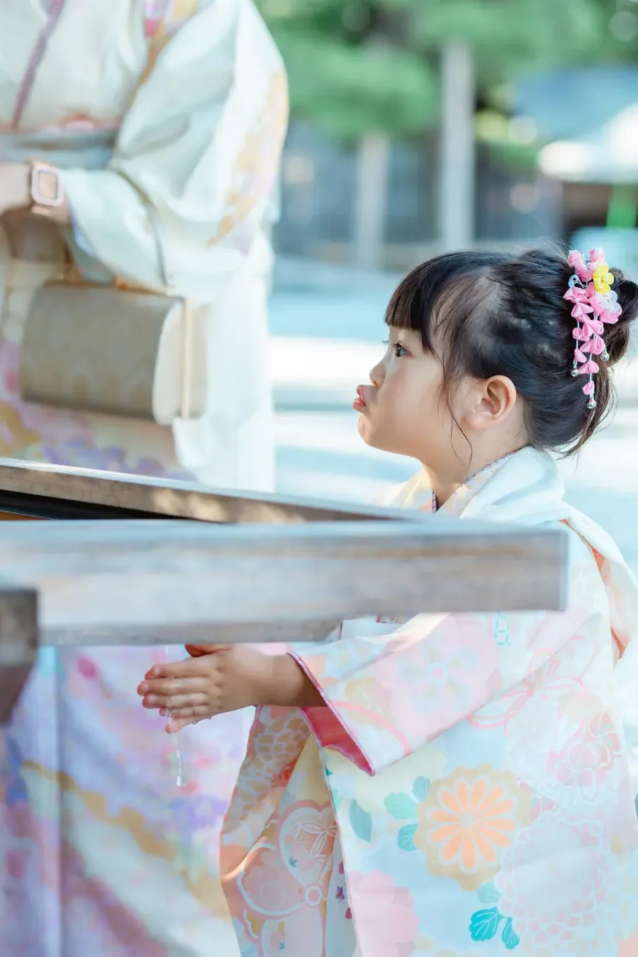伊勢山皇大神宮の手水舎で両手に水を受ける3歳の女の子、七五三の着物姿（横浜）