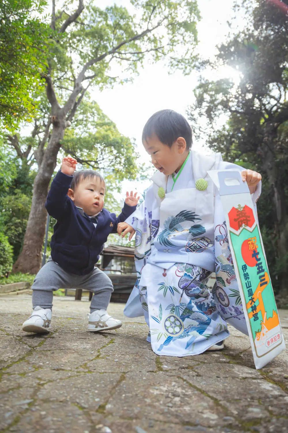 年下の男の子とじゃれ合って笑う3歳の男の子、白い被布姿の七五三の兄弟カット（伊勢山皇大神宮・横浜）