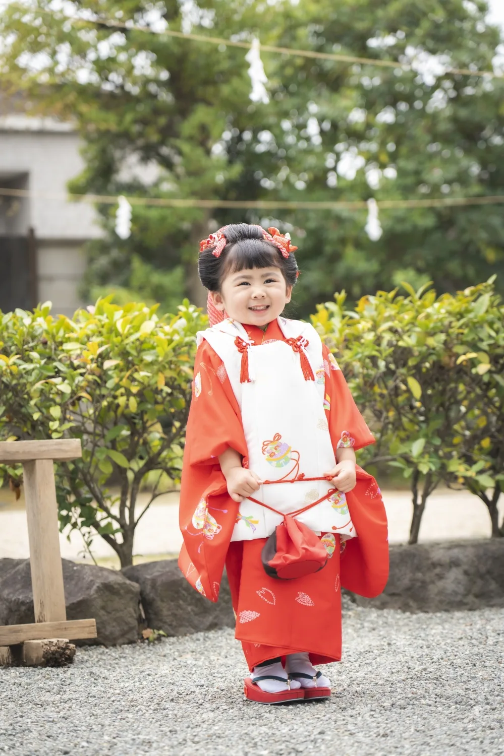境内で笑顔の3歳の女の子、赤い被布姿の全身（七五三・横浜）