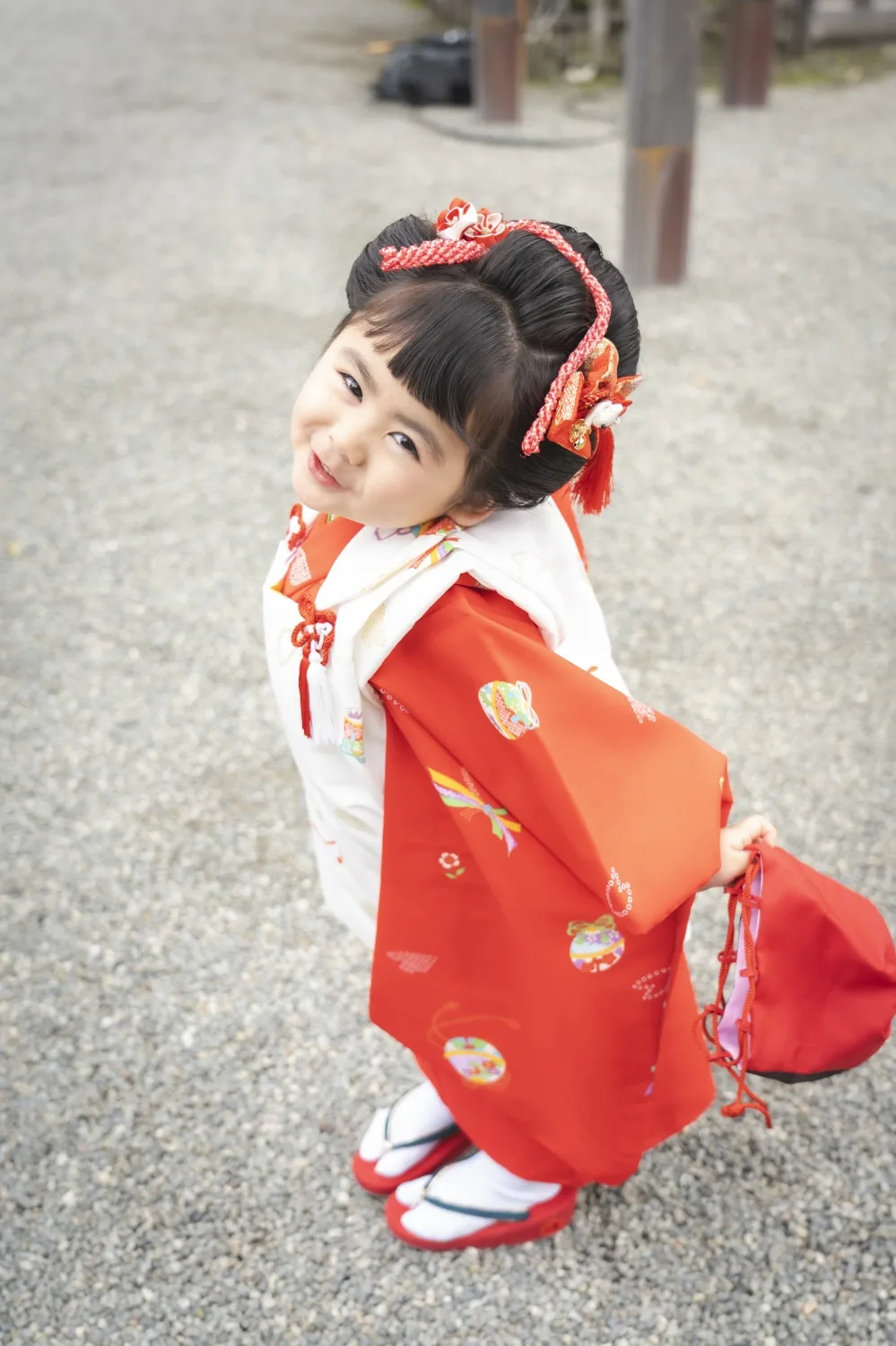 振り返る3歳の女の子、赤い被布の後ろ姿（七五三前撮り・伊勢山皇大神宮）