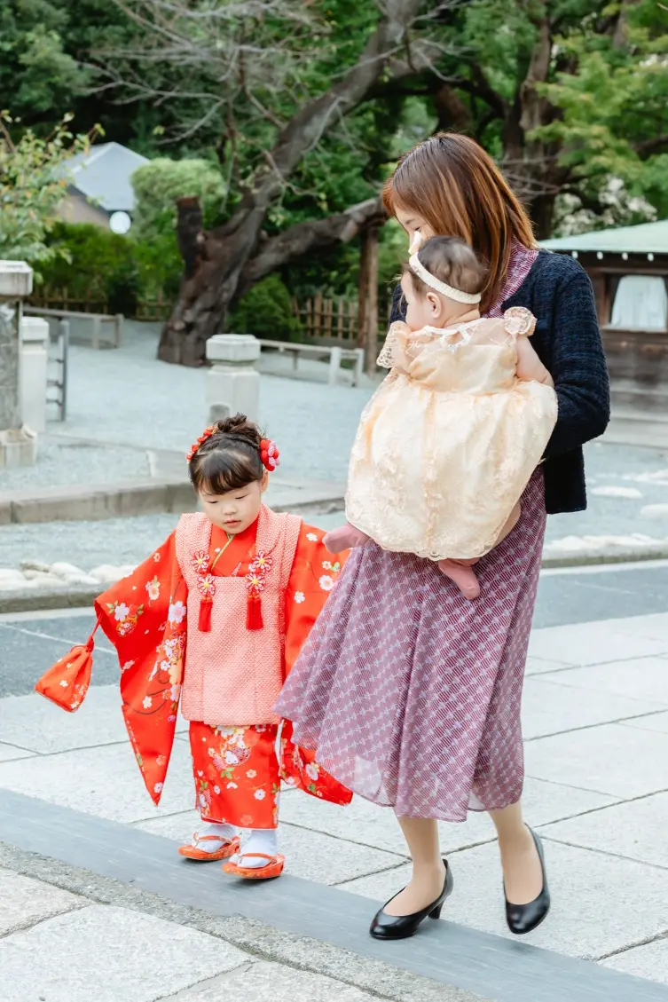 妹を抱いた母と並んで境内の石畳を歩く3歳の女の子、七五三（伊勢山皇大神宮・横浜）