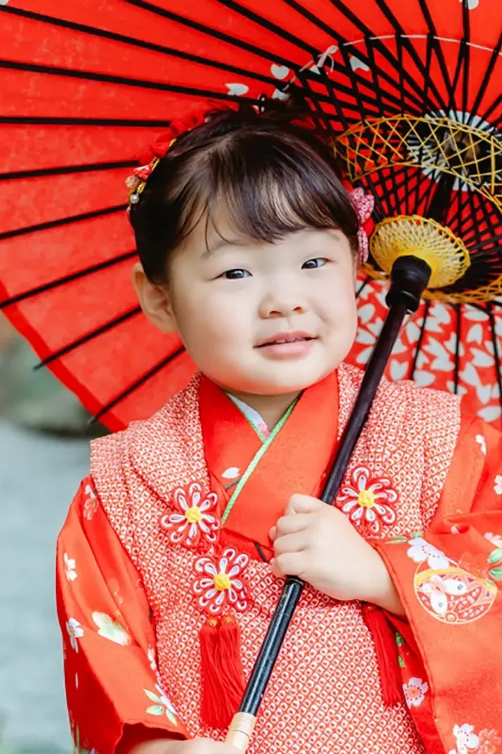 赤い和傘をさす赤い被布姿の3歳の女の子の七五三写真（伊勢山皇大神宮・横浜）