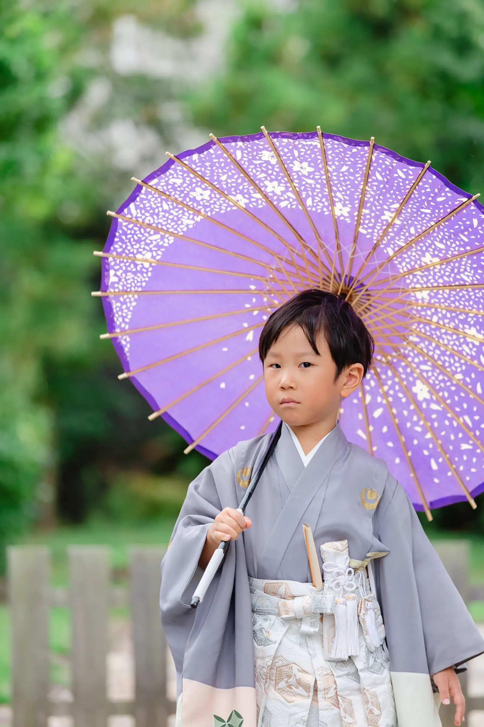 紫の和傘を担ぎ横目で遠くを見る羽織袴姿の男の子、七五三前撮り（伊勢山皇大神宮・横浜）