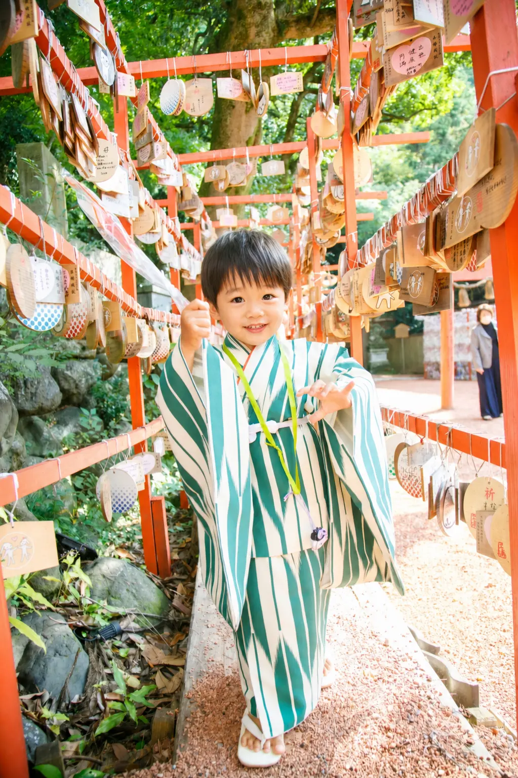 絵馬が並ぶ通路に立つ3歳の男の子の全身、深緑と生成りの着物｜石浦神社の七五三出張撮影（金沢）