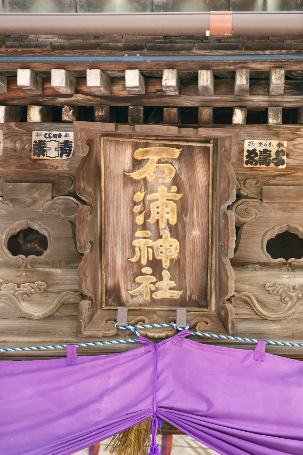 「石浦神社」の扁額と社殿の木彫り、紫の幕｜金沢の七五三出張撮影