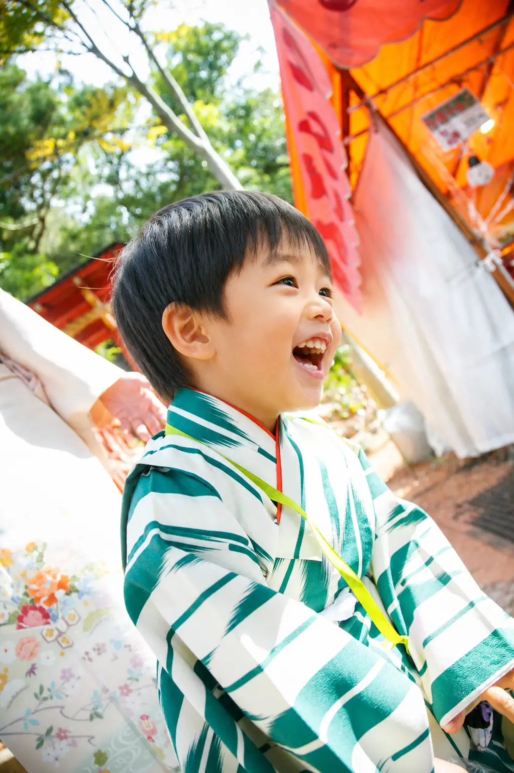 境内で声を上げて笑う3歳の男の子、深緑と生成りの着物｜石浦神社の七五三出張撮影（金沢）