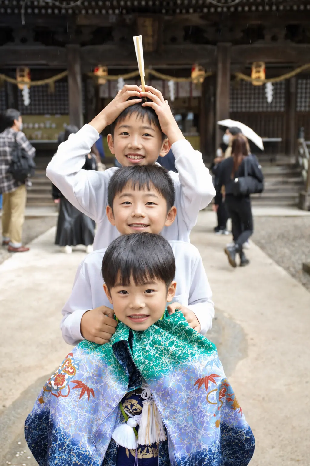 石浦神社の参道で縦一列に並ぶ三兄弟、先頭は5歳の羽織袴姿の七五三