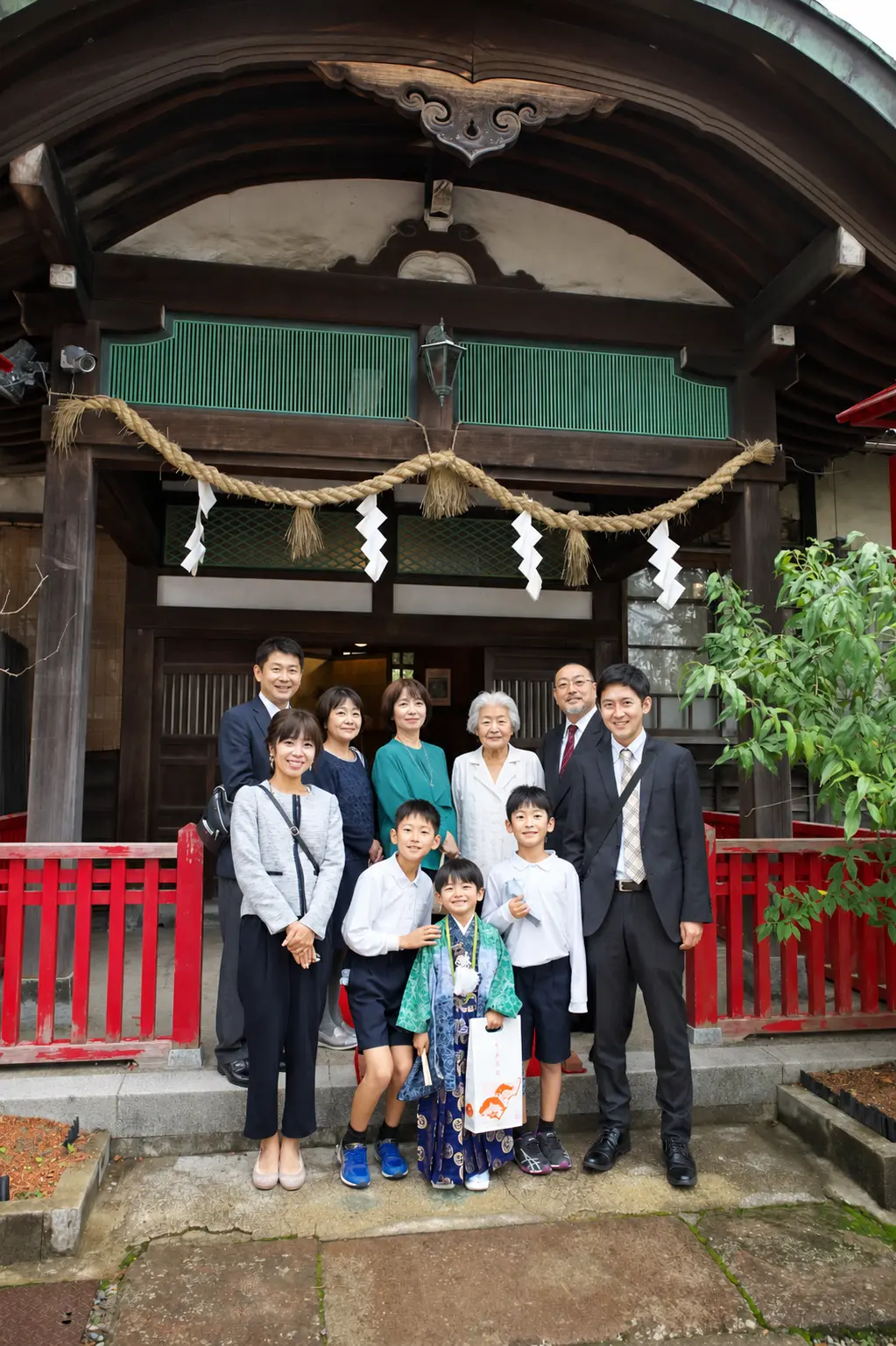 石浦神社の社殿前に並ぶご家族10人の集合写真、中央は5歳の羽織袴姿の男の子の七五三