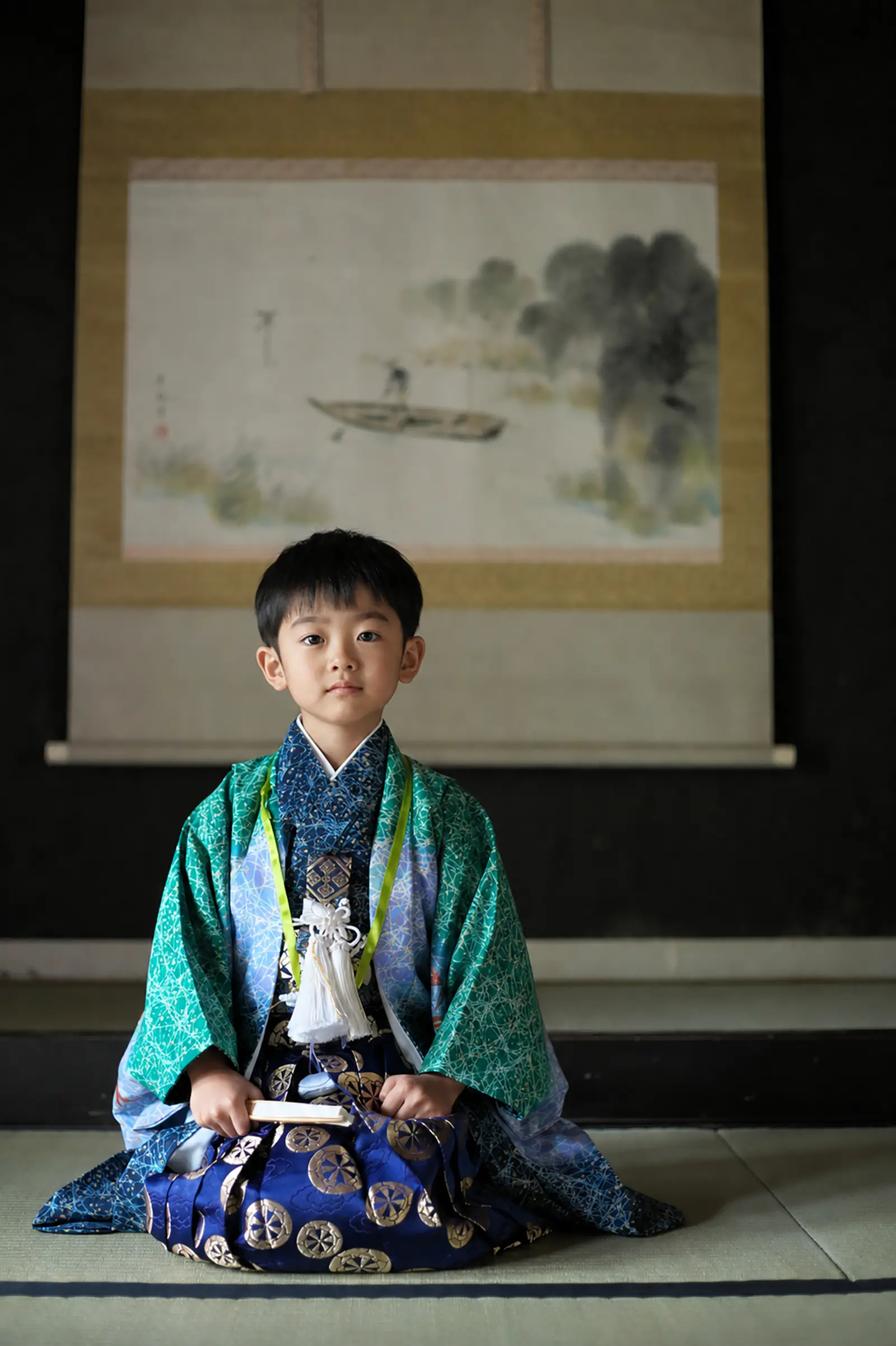 掛軸を背に畳の上で正座する5歳の男の子、緑の羽織と車輪柄の袴の七五三（金沢）