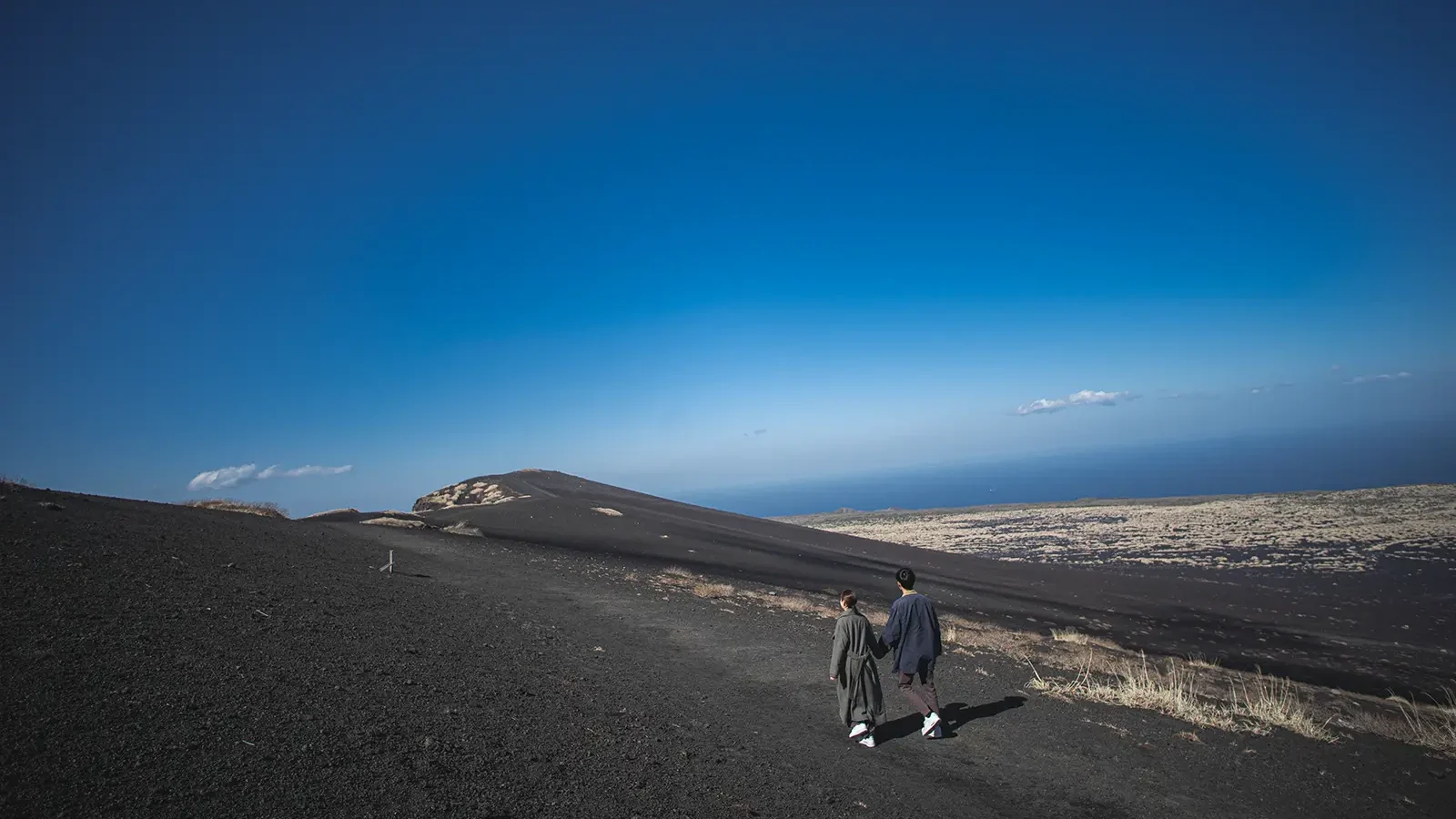 伊豆大島の裏砂漠を歩くカップルのロケーションフォト