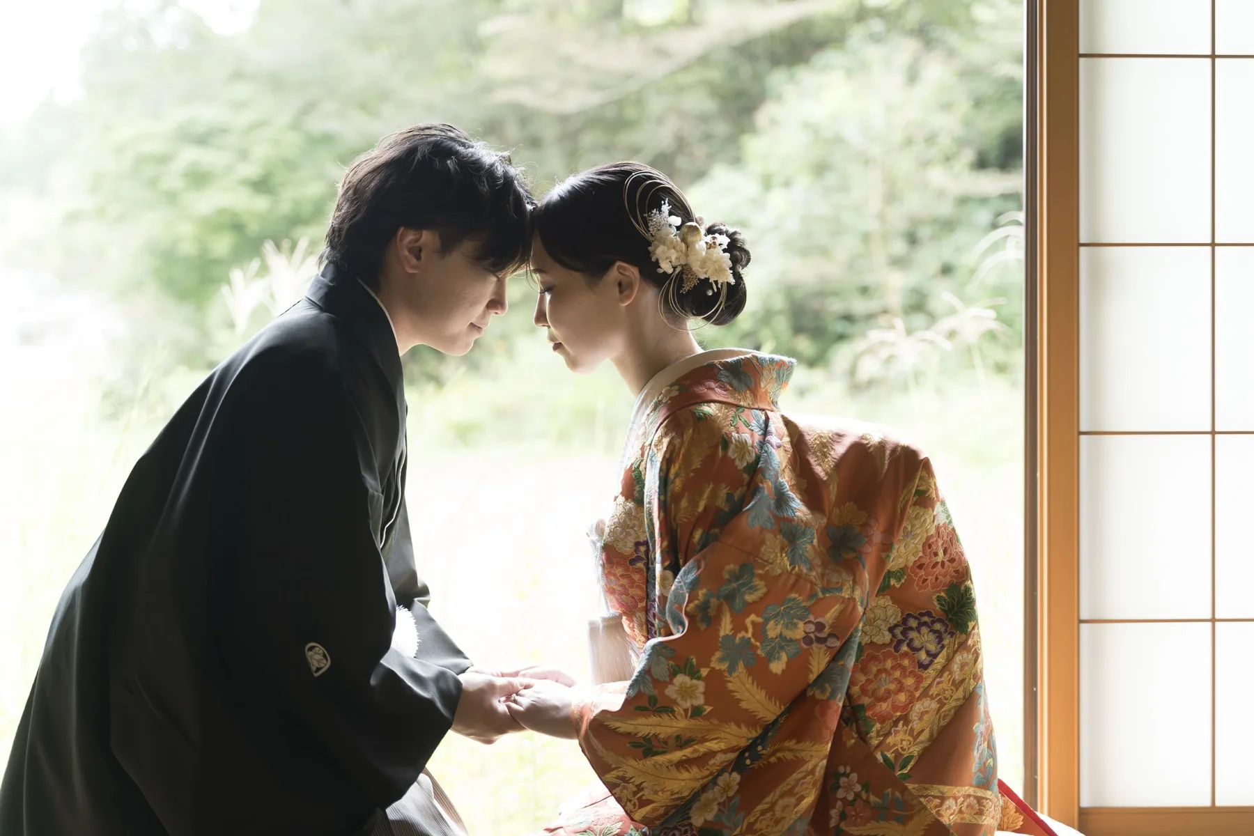 額を寄せ合う色打掛の新婦と黒紋付の新郎、金沢の和装フォトウェディング