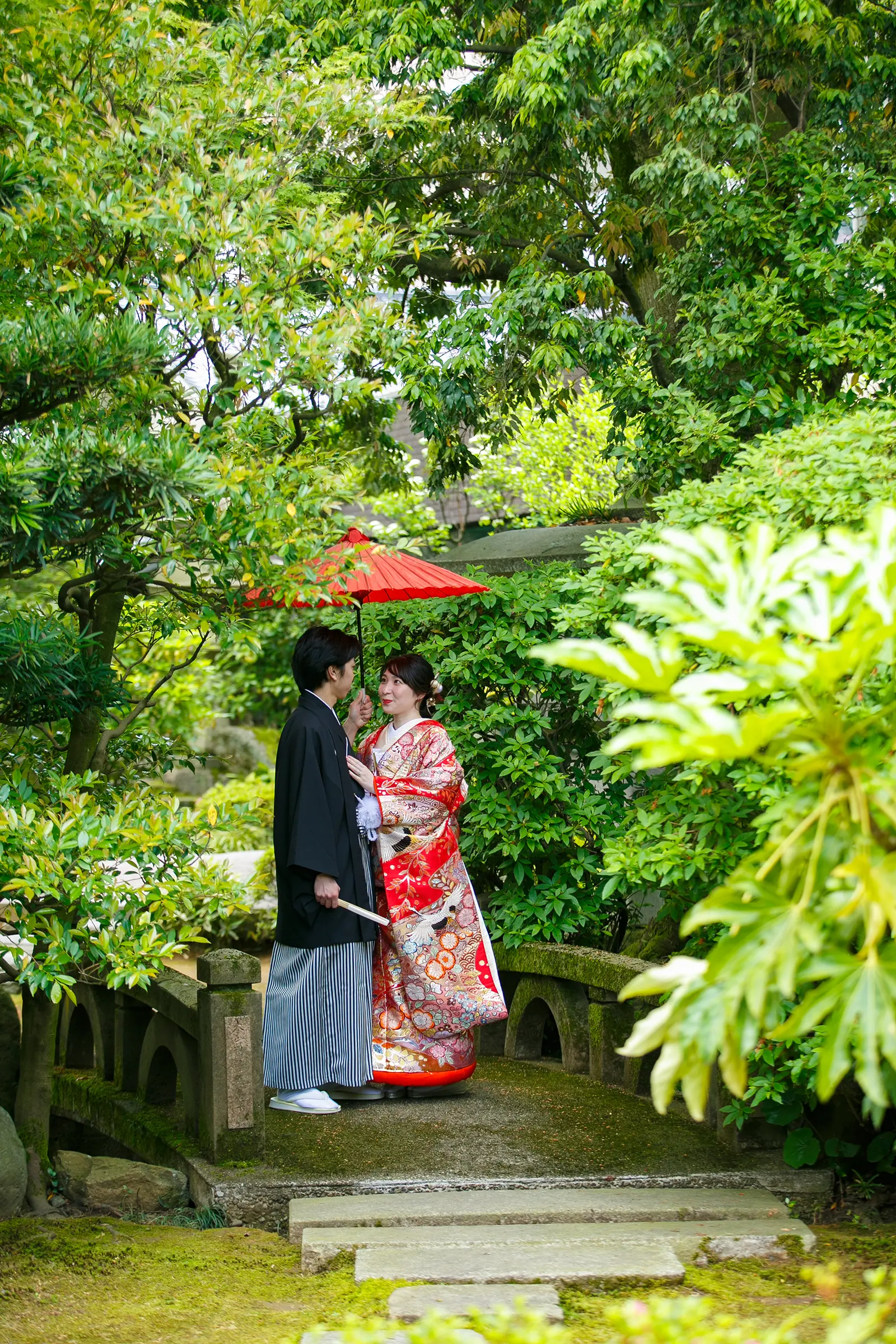松任ふるさと館の障子前で色打掛の花嫁と紋付袴の新郎が寄り添うシルエット風の和装写真