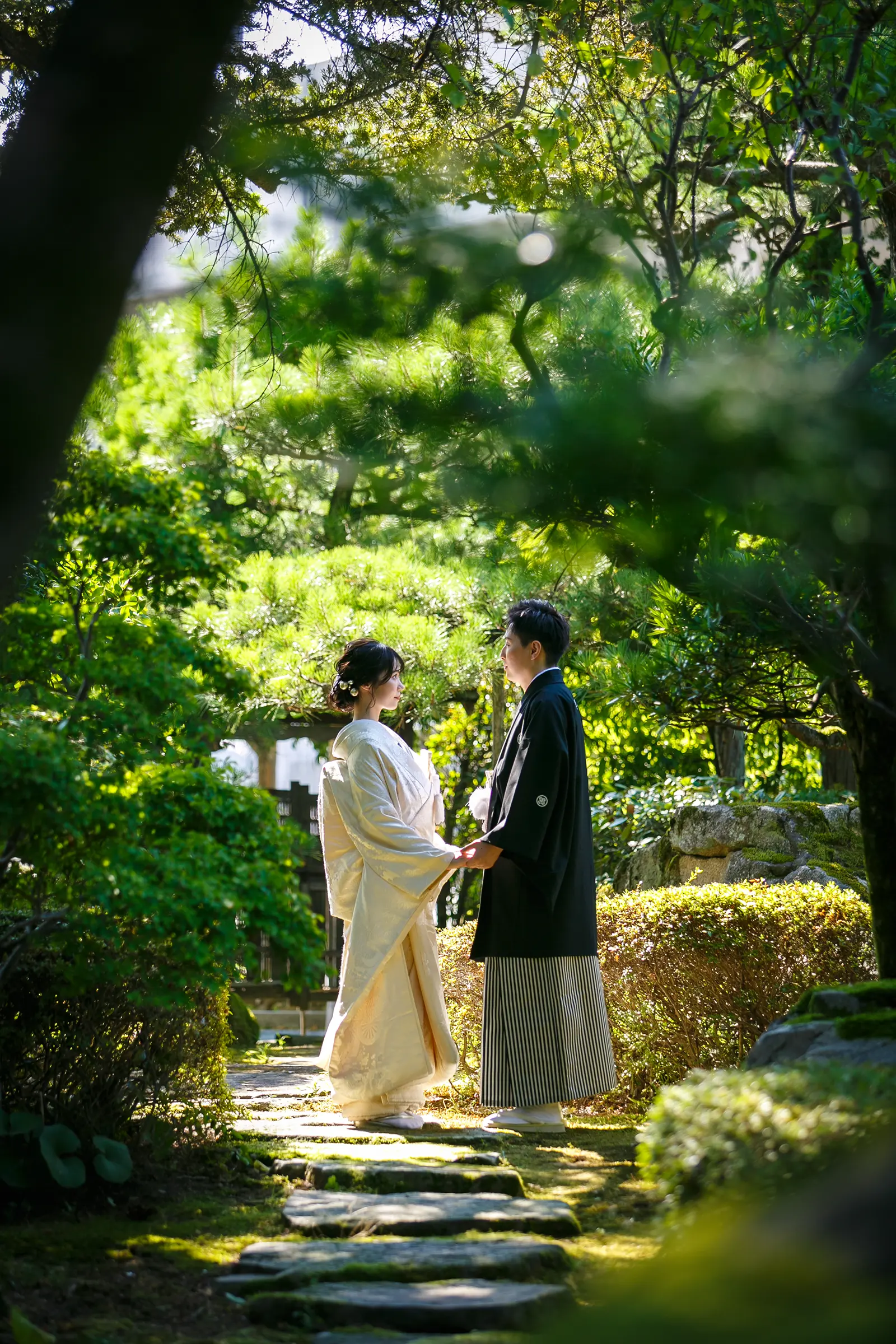 松任ふるさと館の日本庭園で白無垢の花嫁と紋付袴の新郎が近く寄り添う和装前撮り