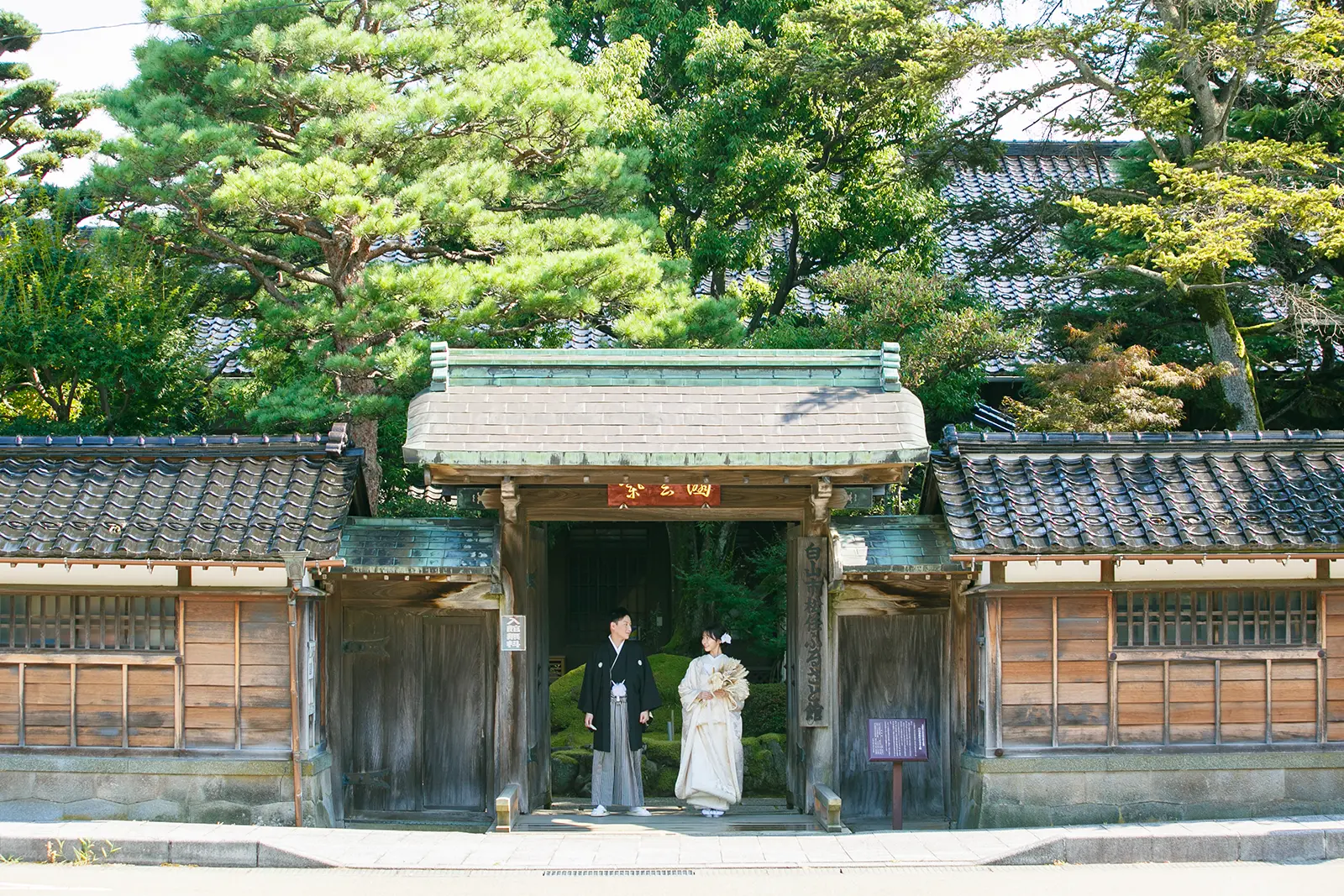 松任ふるさと館の日本庭園で白無垢の花嫁と紋付袴の新郎が向かい合う和装前撮り