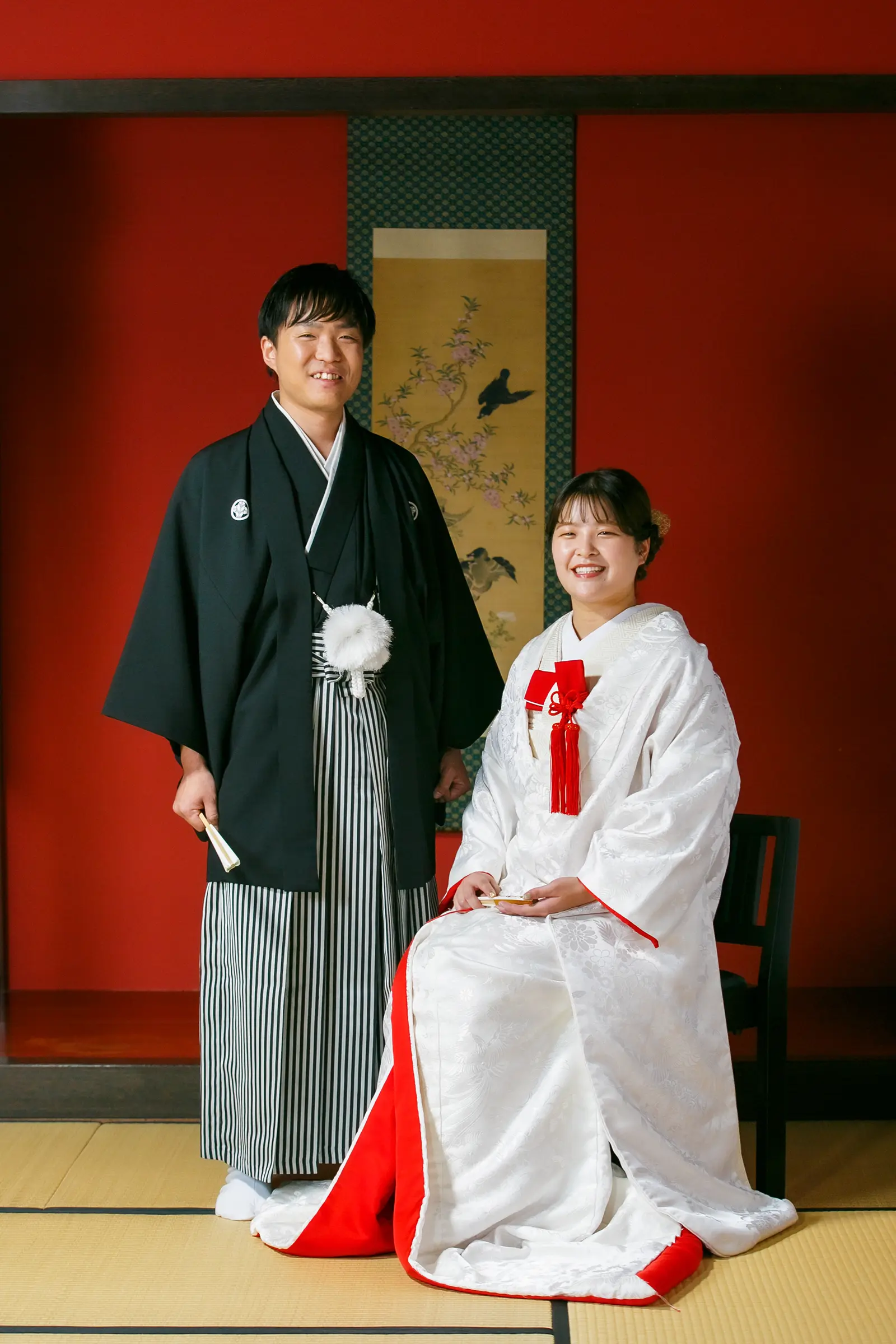 松任ふるさと館の赤い和室で白無垢と紋付袴姿を正式ポーズで撮影した写真
