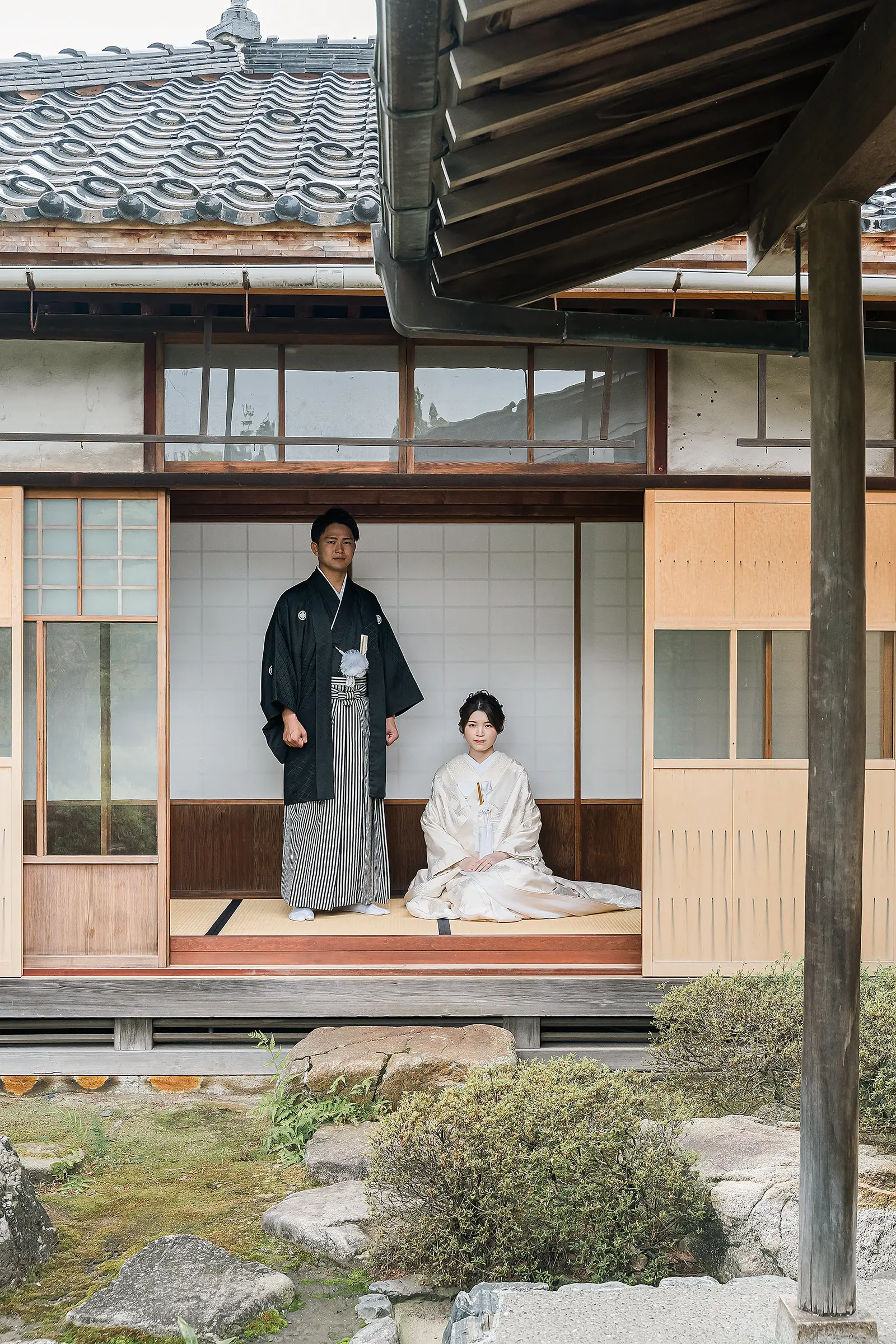 松任ふるさと館の縁側で白無垢の花嫁と紋付袴の新郎を縦構図で撮影した和装前撮り