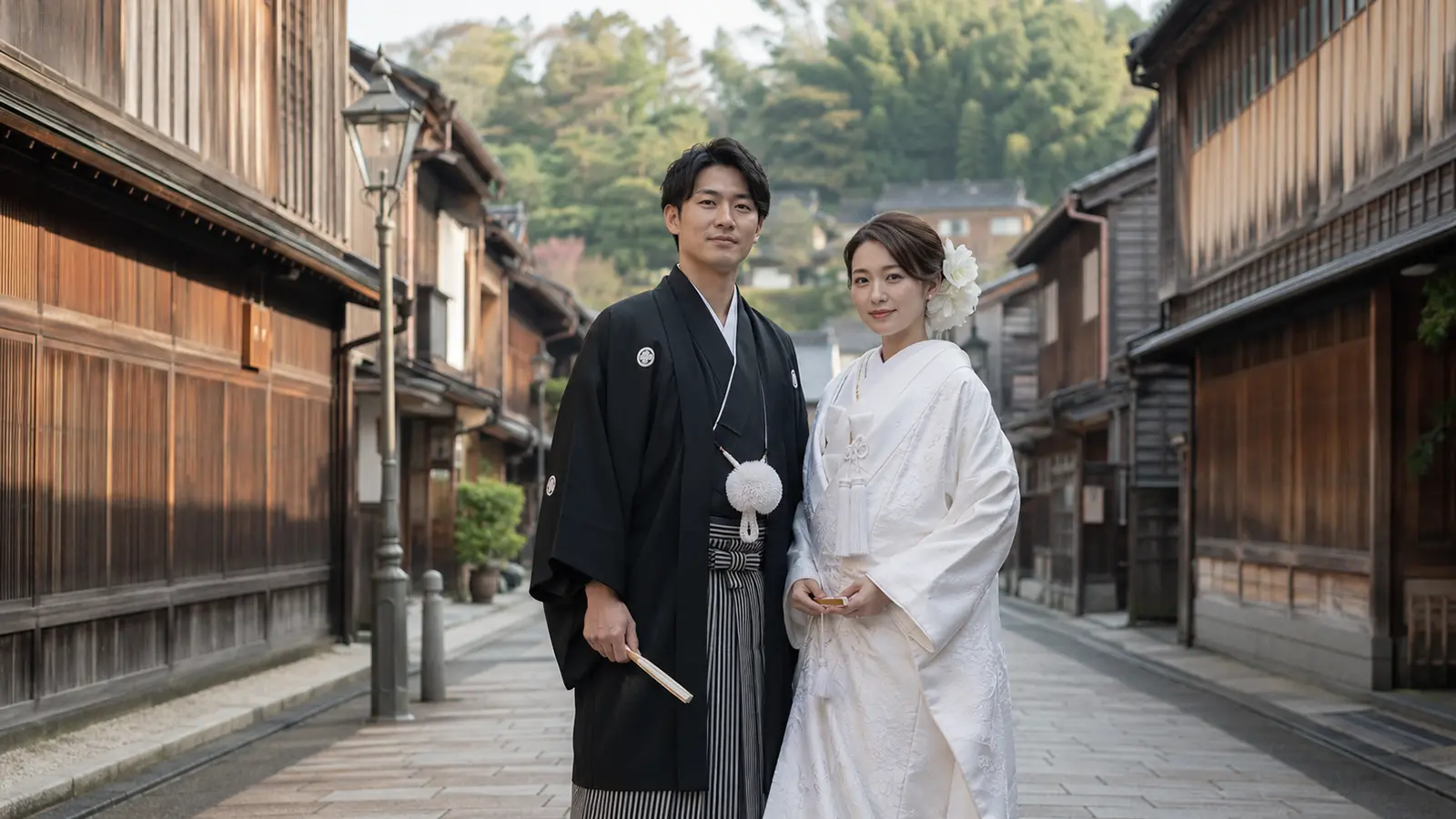 金沢ひがし茶屋街の町並みを背景に白無垢の新婦と紋付袴の新郎が並ぶ和装フォトウェディング写真