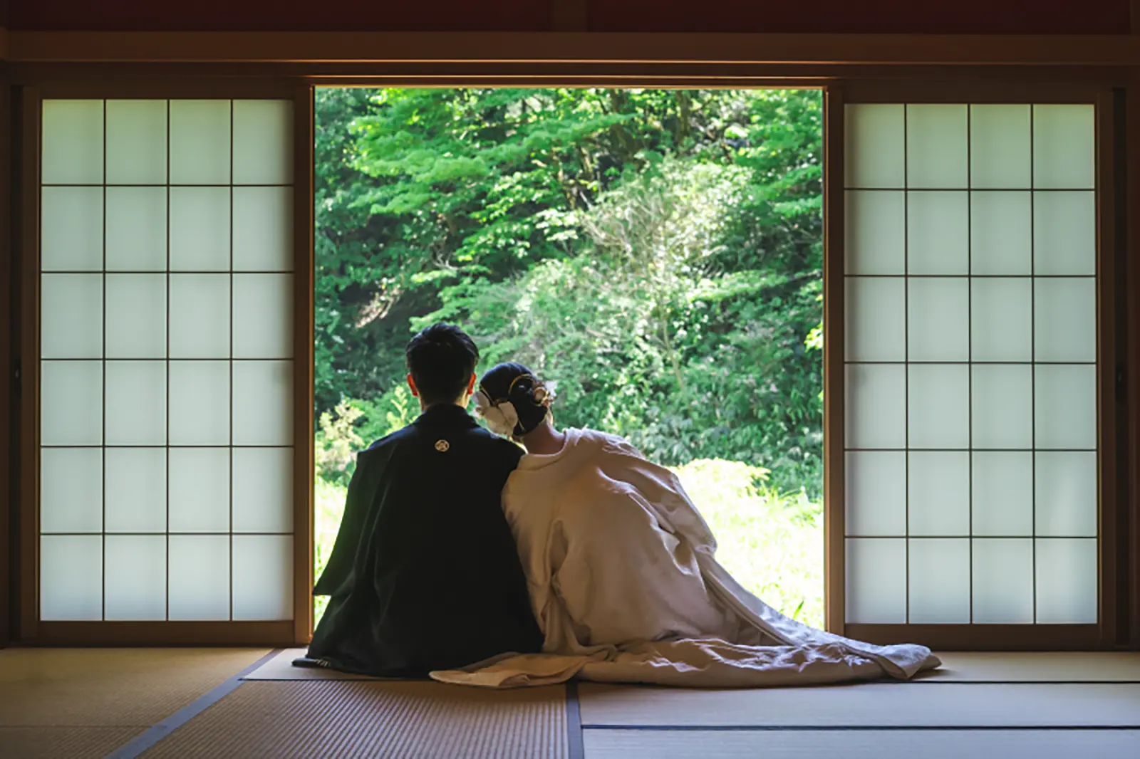 和室スタジオの窓辺で寄り添う新郎新婦の和装前撮り写真