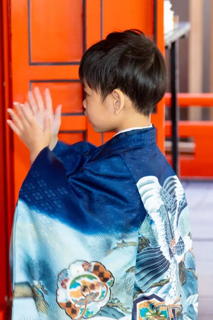 拝殿の前で両手を合わせて拍手を打つ羽織袴の5歳の男の子の後ろ姿、七五三（金澤神社・金沢）