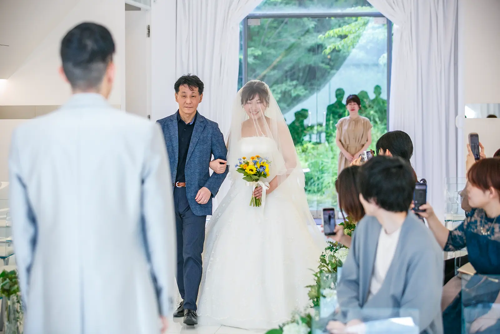 金沢国際ホテルのチャペルで家族に見守られながら花嫁が入場する挙式風写真