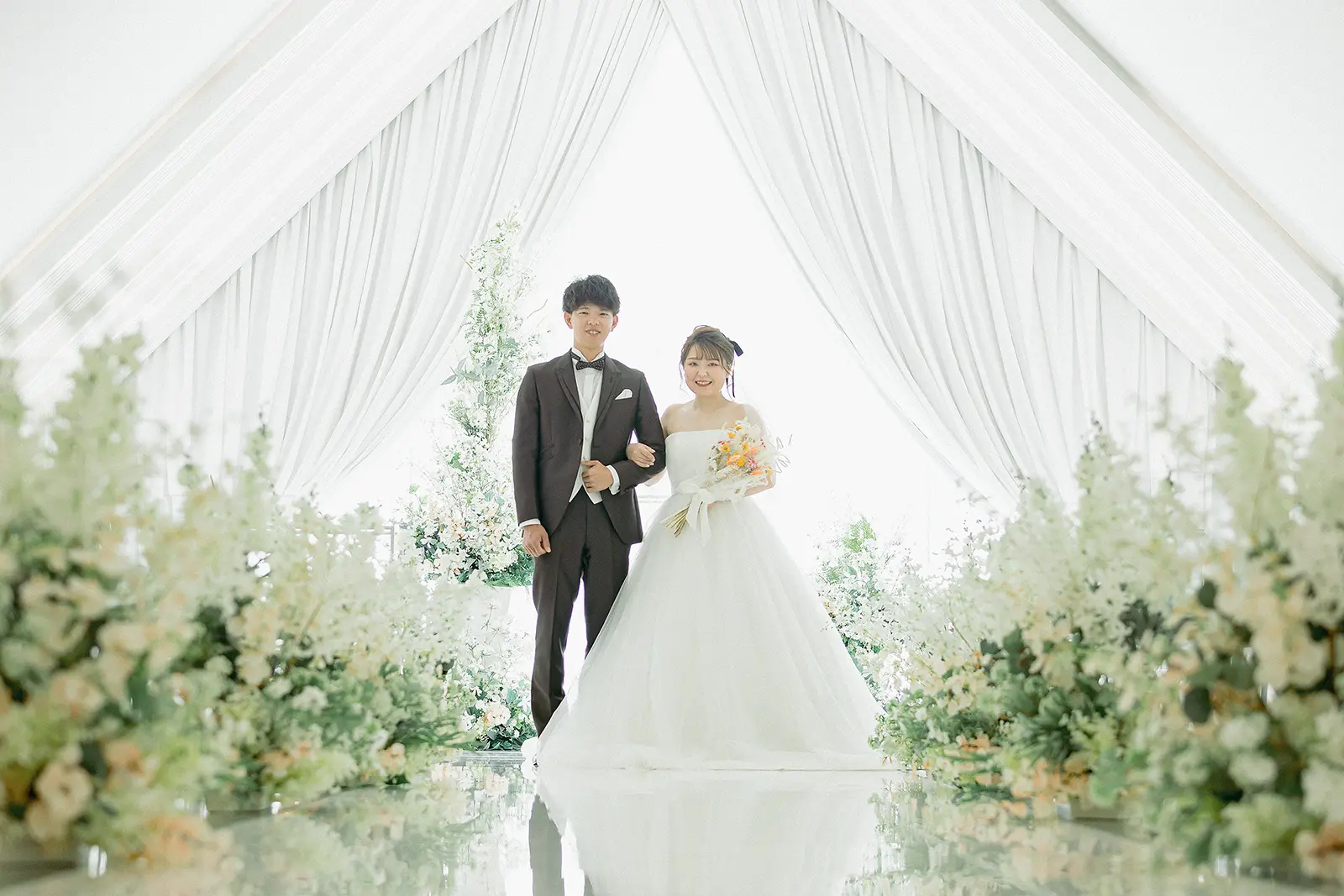 金沢国際ホテルのチャペルで花に囲まれて立つ新郎新婦のフォトウェディング写真