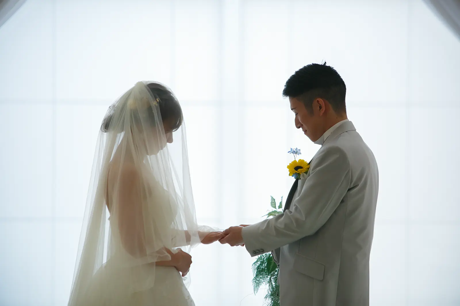 金沢国際ホテルのチャペルで新郎が花嫁の手を取る指輪交換風の写真
