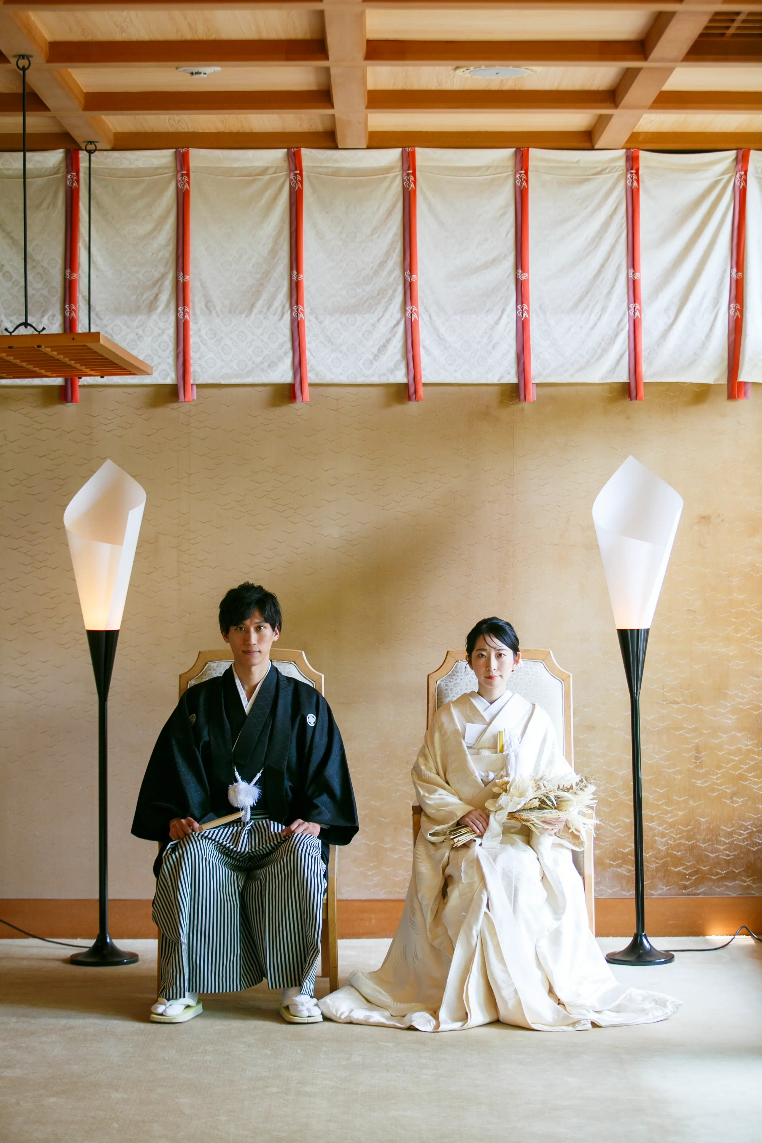 金沢国際ホテルの神殿の和室で椅子に座る洋髪に白無垢の新婦とドライフラワーブーケ、紋付袴の新郎