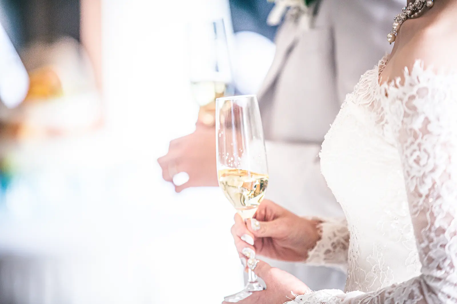 フォトウェディング撮影後の会食シーンでシャンパングラスを持つ新婦