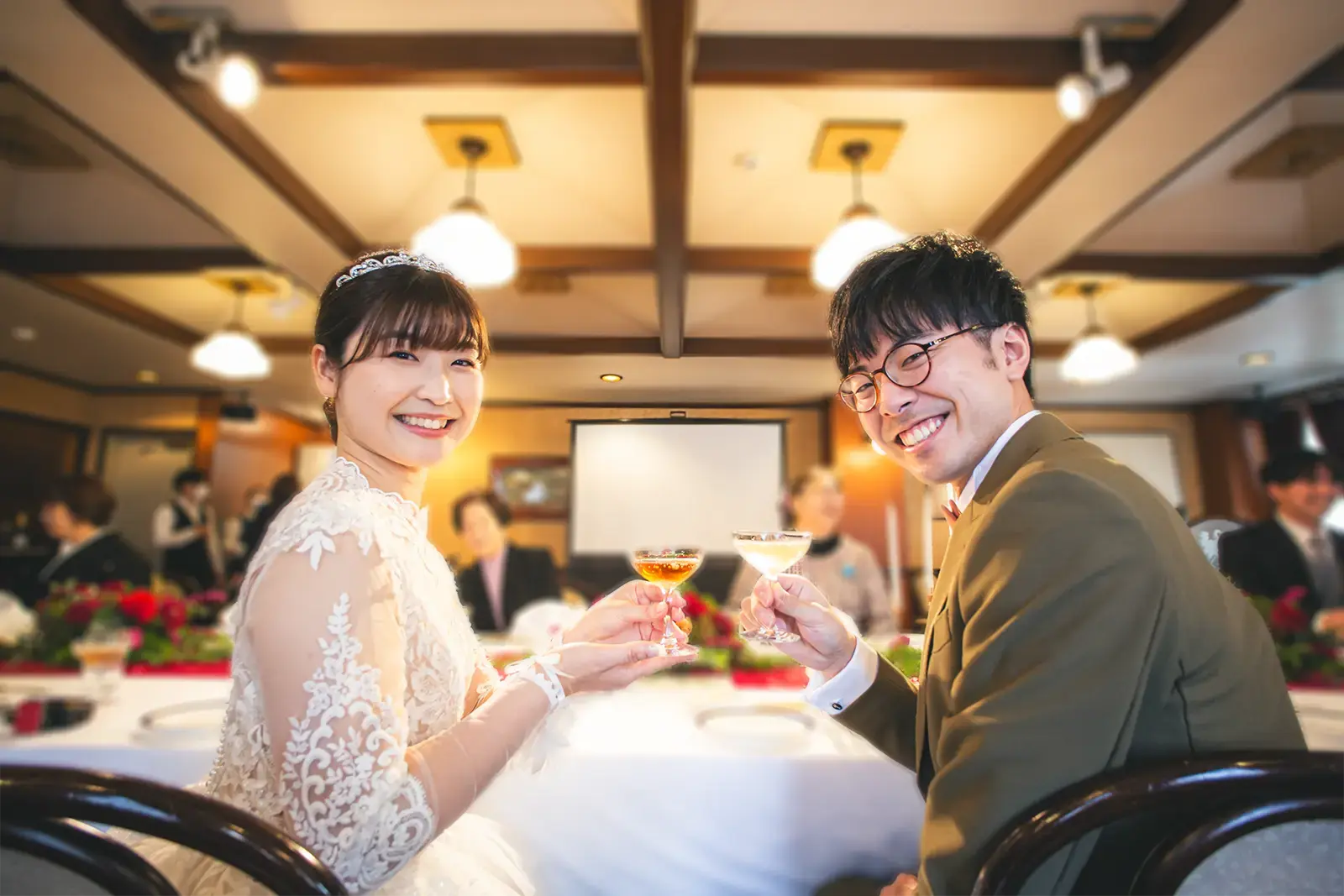 フォト会食のイメージとして会食会場で乾杯する新郎新婦