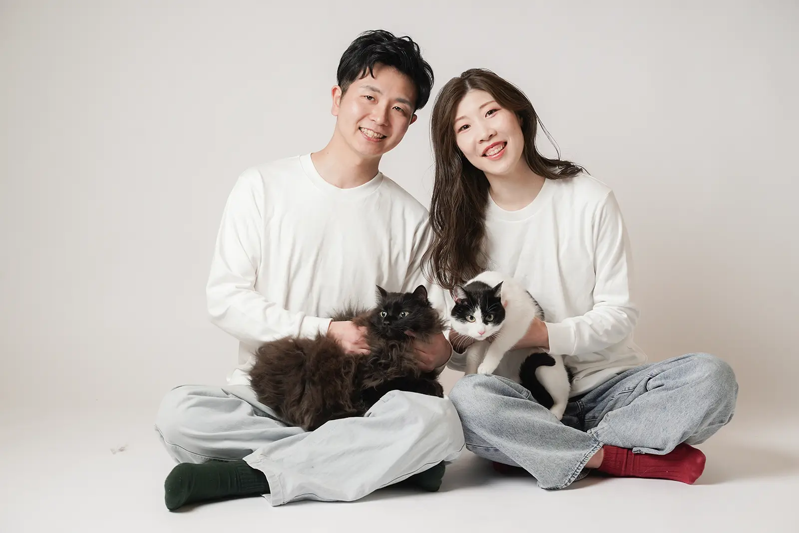 猫と一緒に白い服で撮影するカップルの記念写真