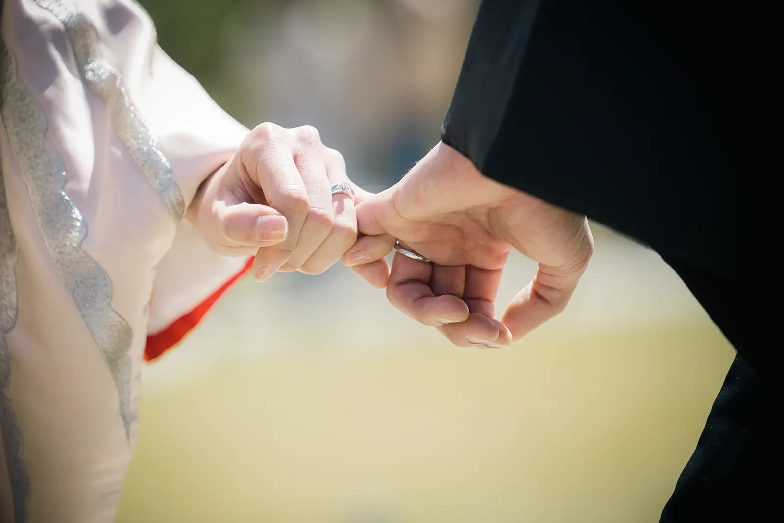 和装姿の新郎新婦が小指を重ねる手元と指輪の写真