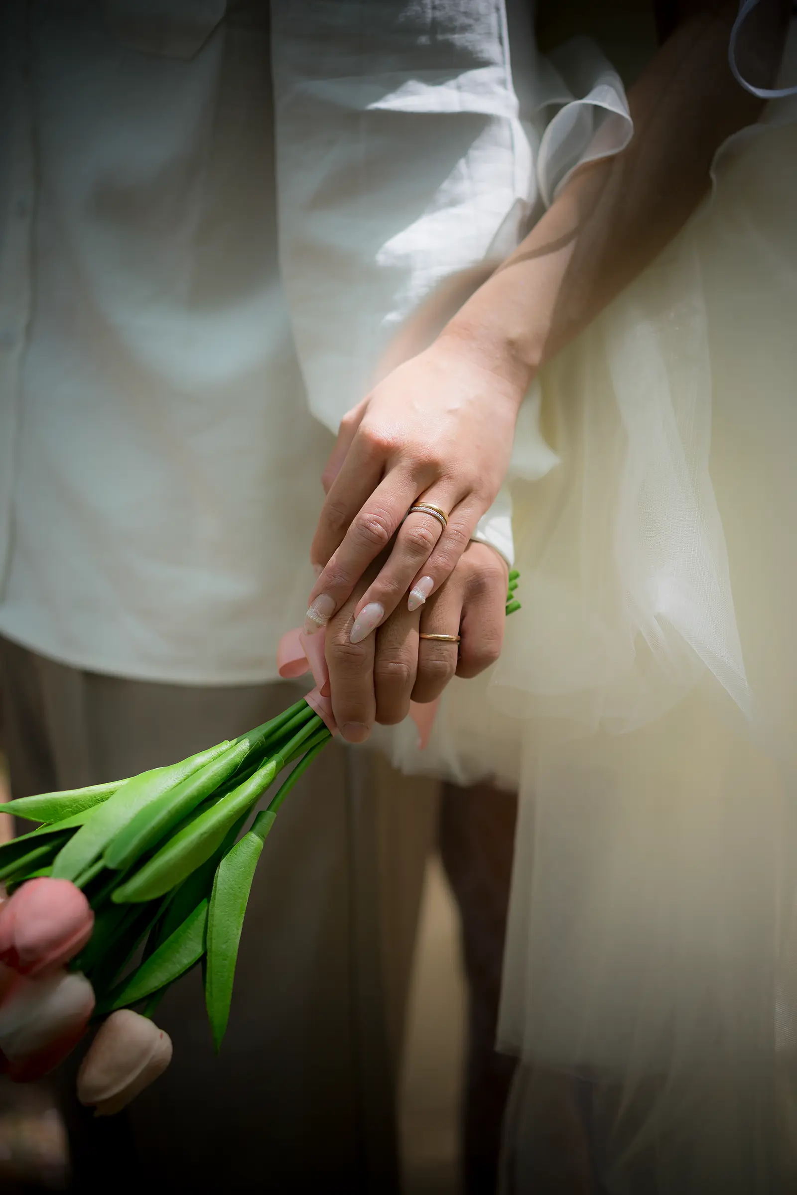 ウェディングドレス姿の花嫁がブーケを持ち指輪を見せる手元写真