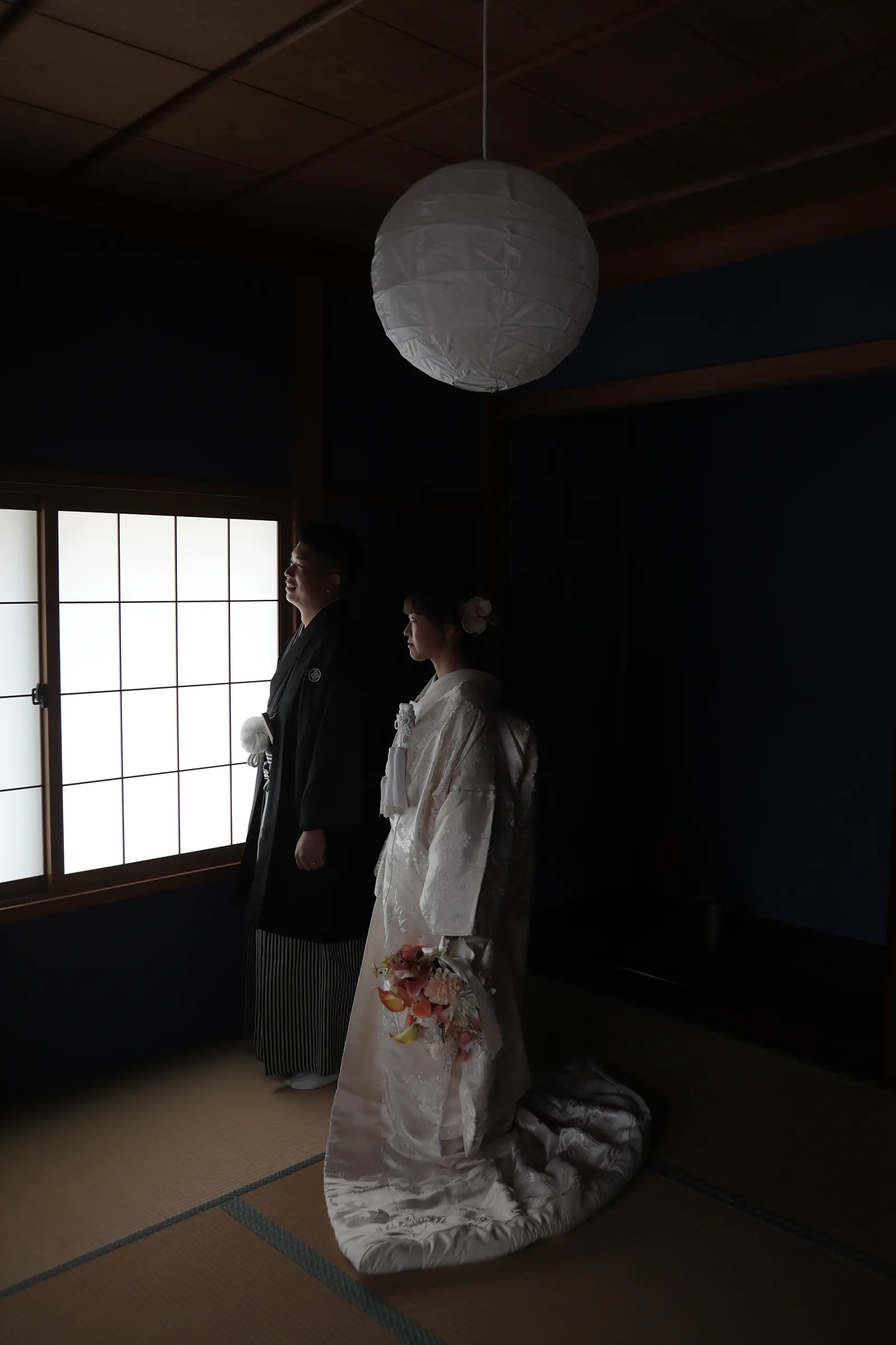 障子の前に立つ和装姿の新郎新婦のシルエット写真