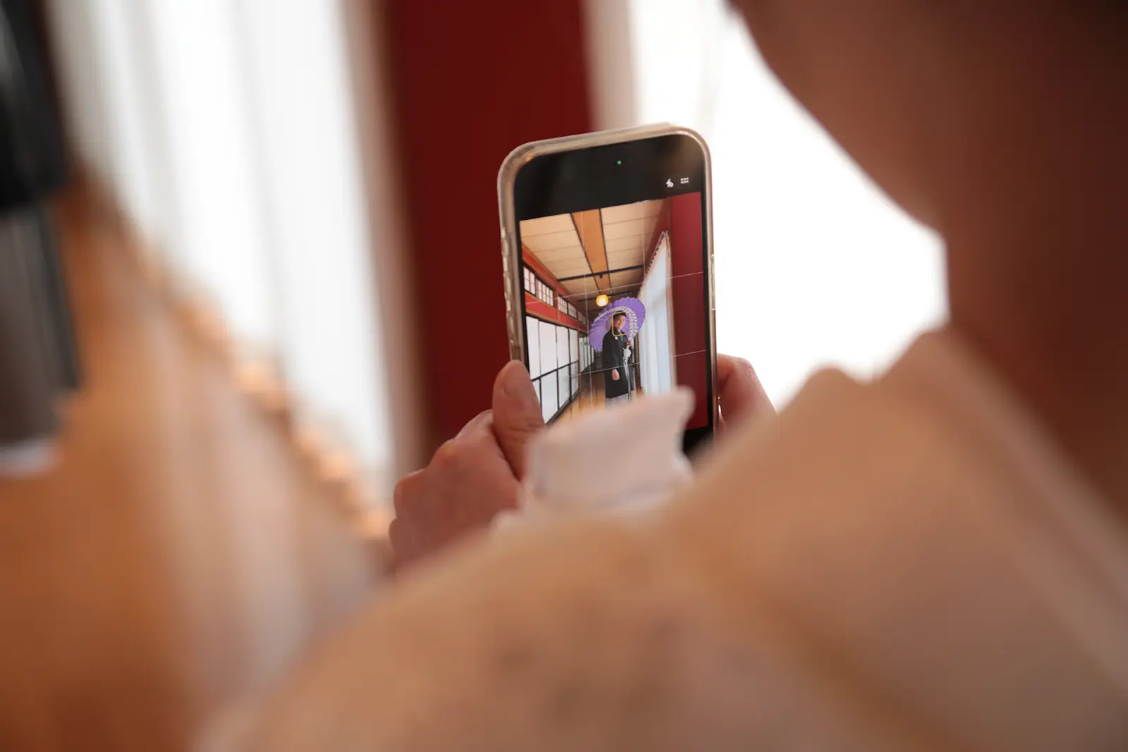 スマートフォンで和装姿を撮影している様子を写した写真