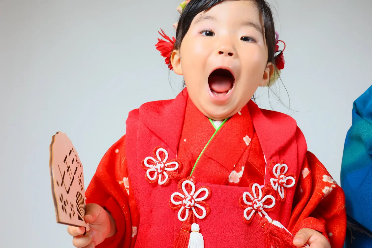 口を大きく開けて驚いた顔をする3歳の女の子、赤い被布姿の七五三スタジオ撮影（金沢店）